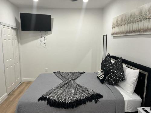a bedroom with a bed with a television on the wall at Incredible comfortable apartments near the airport and beaches in Tampa