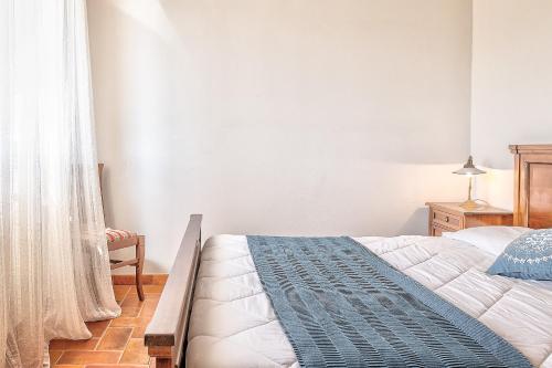 a bedroom with a bed with a blue and white blanket at Borgo del Faggio - Case Vacanza in Montepulciano