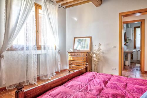 a bedroom with a large pink bed and a window at Borgo del Faggio - Case Vacanza in Montepulciano