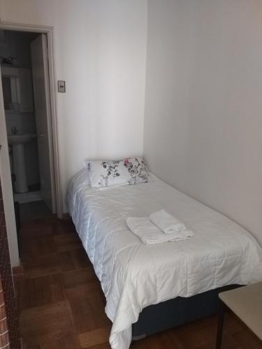 a white bed with two towels on it in a room at Vista al Mar Departamento - Edificio Acapulco in Viña del Mar