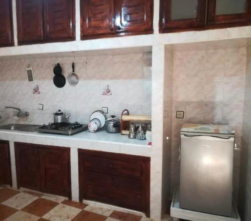 - une cuisine avec des placards en bois, un évier et une cuisinière dans l'établissement Dar Abdlouahed, à Chefchaouen
