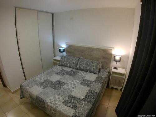 1 dormitorio pequeño con 1 cama y 2 mesitas de noche en Hermoso dpto. con patio en Córdoba