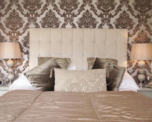 a bedroom with a large bed with two lamps at Maenan Abbey Hotel in Llanrwst