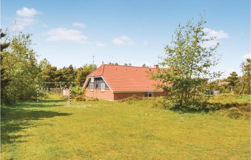 a house with a red roof in a field at Lovely Home In Fanø With Kitchen in Fanø
