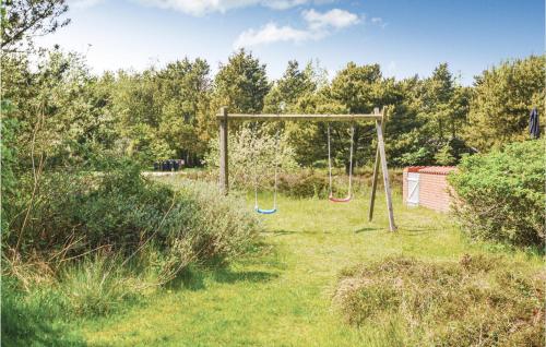 a swing set in a grassy yard with trees at Lovely Home In Fanø With Kitchen in Fanø