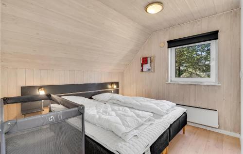a bed in a small room with a window at Lovely Home In Fanø With Kitchen in Fanø