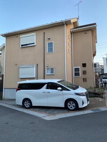 a white van parked in front of a building at GuestHouse MISAKI 一棟貸切駐車場2台最寄駅はJR石山駅瀬田南郷ゴルフ場近し琵琶湖京都宇治奈良大阪の観光は便利です in Otsu