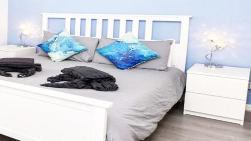 a white bed with blue pillows on top of it at Agiou Louka Villa Mykonos in Megali Ammos