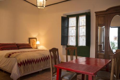 a bedroom with a bed and a table and window at Cielo Arriba Casa in Humahuaca