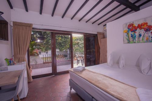 a bedroom with a bed and a view of a patio at Aguacatala Hotel Boutique in Medellín