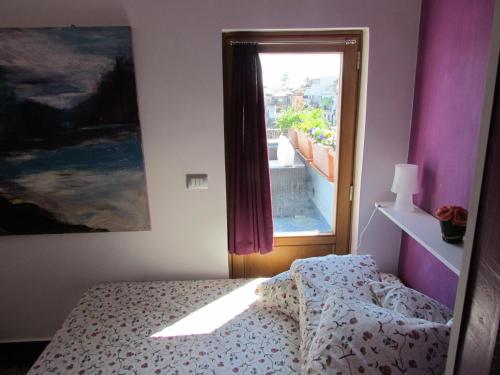 Schlafzimmer mit einem Bett und einem Fenster in der Unterkunft La Terrazza sul Mare in Aci Castello