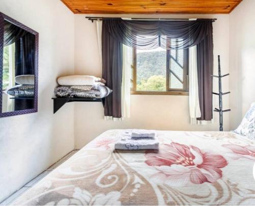 ein Schlafzimmer mit einem Bett mit Blumenmuster darauf in der Unterkunft Casa de Campo Vó Almerinda in Urubici