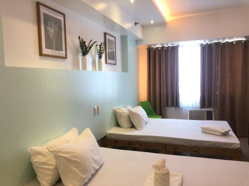 a hotel room with two beds and a window at Premiere Haven MOA Staycation in Manila