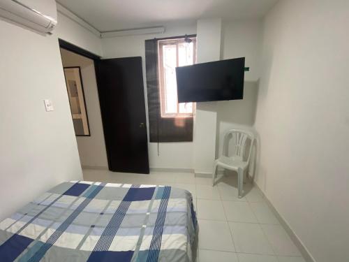 a bedroom with a bed and a flat screen tv at Cómodo apto 203 muy cerca a CENTRO COMERCIAL UNICENTRO CUCUTA in Cúcuta