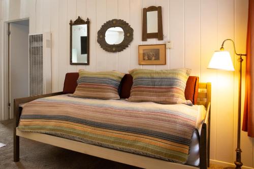 a bedroom with a bed with a blanket and a mirror at June Lake Villager in June Lake