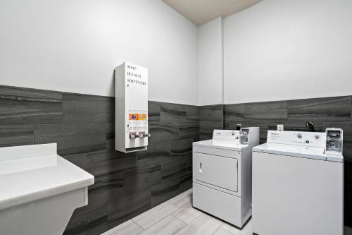 uma lavandaria com electrodomésticos brancos e pisos em madeira em Holiday Inn Express Hotel & Suites Kilgore North, an IHG Hotel em Kilgore