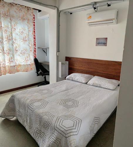a bedroom with a bed and a chair in it at La Curva Apartamentos in Cali
