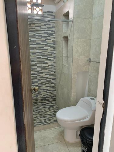 a bathroom with a toilet and a shower at La Curva Apartamentos in Cali