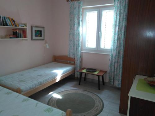 a small room with two beds and a window at Casa Liliana By the Sea in Mali Lošinj