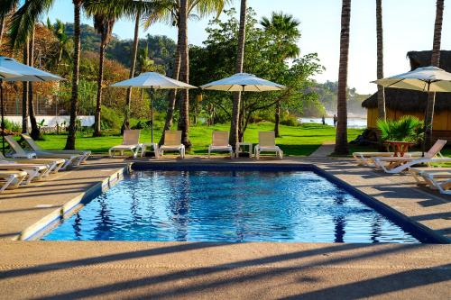 a swimming pool with chairs and umbrellas at Hotel Ysuri San Pancho in San Francisco