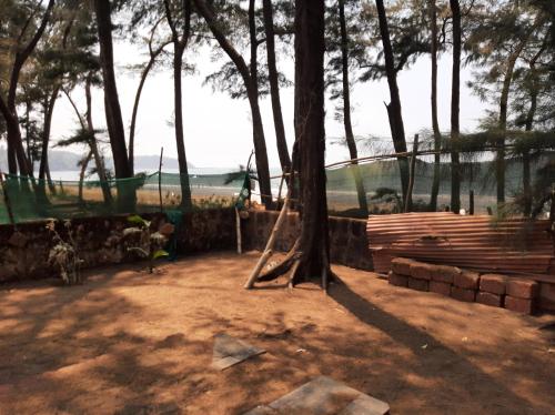 a playground with a tree and a fence at Dias guest house in Canacona