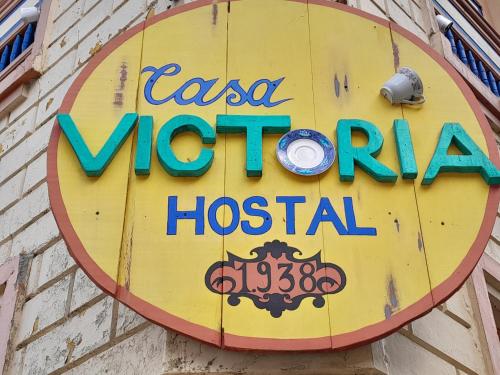 a sign for a las vegas motel hospital on a brick wall at HOSTAL CASA VICTORIA PIJAO in Pijao