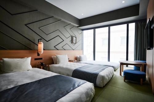 a hotel room with two beds and a window at Asakusa View Hotel Annex Rokku in Tokyo