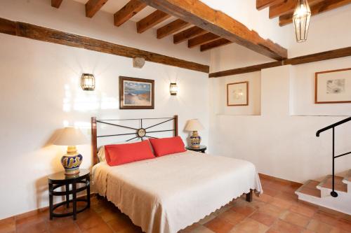 Un dormitorio con una cama con almohadas rojas. en La Casa Veintidós en Guanajuato