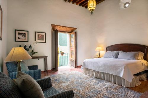 1 dormitorio con cama, sillas y ventana en La Casa Veintidós, en Guanajuato