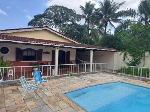 uma villa com piscina em frente a uma casa em Casa Guarujá c/ piscina grande no Guarujá
