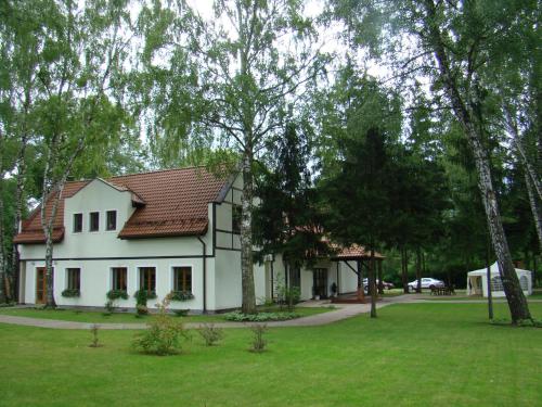 a white house with a yard and trees at Hotel Restauracja Cztery Pory Roku in Orneta