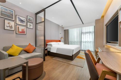 um quarto de hotel com uma cama e um sofá em Home2 Suites by Hilton Shenzhen Nanshan Science & Technology Park em Shenzhen