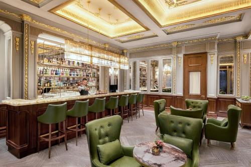 um restaurante com um bar com cadeiras verdes em Metropolitan Residence em Xangai