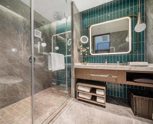 uma casa de banho com um chuveiro, um lavatório e um espelho. em Home2 Suites by Hilton Shenzhen Nanshan Science & Technology Park em Shenzhen