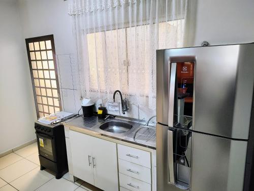eine Küche mit einem Kühlschrank aus Edelstahl und einer Spüle in der Unterkunft Casa Executiva Orla Morena in Campo Grande
