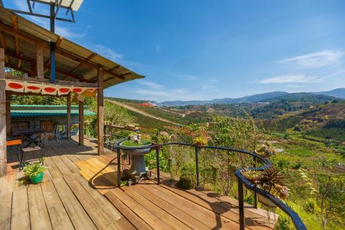 a wooden deck with a view of the mountains at Midori Coffee Farm in Da Lat