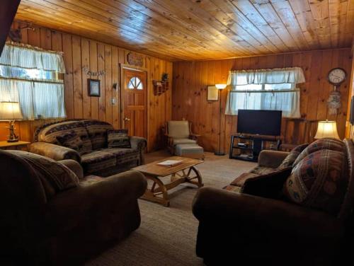 ein Wohnzimmer mit Sofas und einem Flachbild-TV in der Unterkunft Cabin #2 in Strawberry