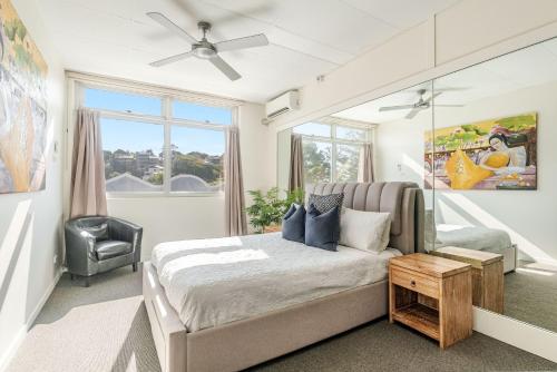 a bedroom with a bed and a chair and a window at The Ritz in Yamba