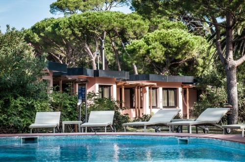 カスティリオーネ・デッラ・ペスカーイアにあるRoccamare Resort - Casa di Levanteのスイミングプール、椅子、家が備わるヴィラです。