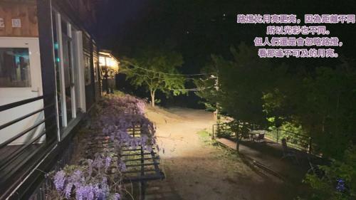 a building with purple flowers outside of it at night at Lala Mountain Homestay‧Cile Farm in Hualing