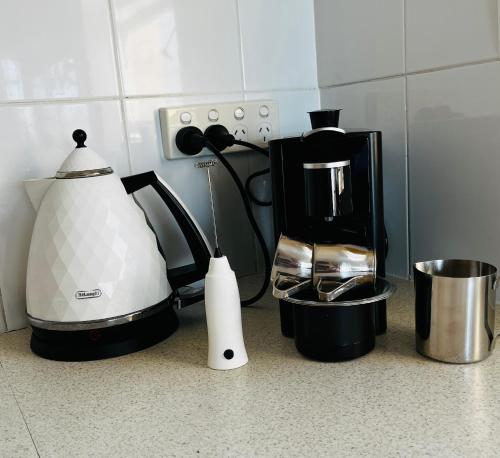 a kitchen counter with a coffee maker and a blender at Eloura Gardens 100m to Beach in Cronulla