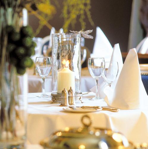 a white table with a candle and glasses on it at Flemings Country House in Cork