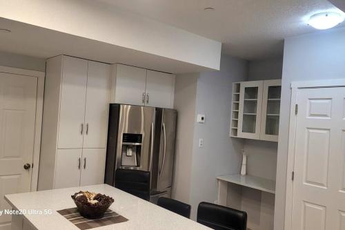 a kitchen with a table and a refrigerator at A very nice Basement ensuite. in Calgary