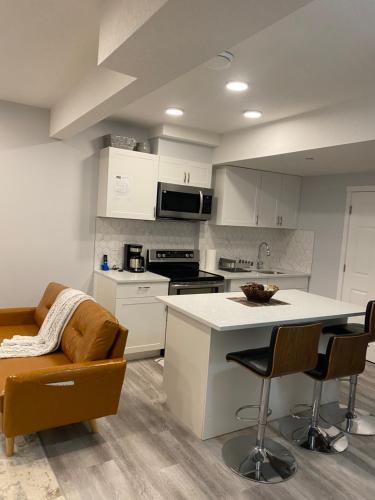 a kitchen with white cabinets and a table and chairs at A very nice Basement ensuite. in Calgary