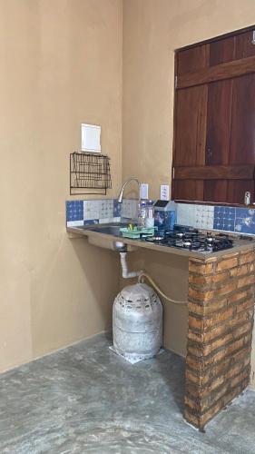 a kitchen with a counter and a sink in a room at Milagres Retrô- Studio in São Miguel dos Milagres