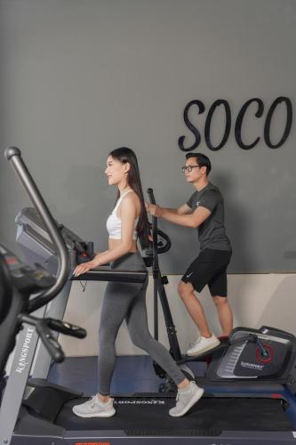 a man and a woman on a treadmill in a gym at Hotel Soco in Da Nang