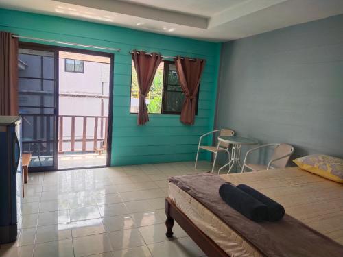 Cette chambre comprend un lit, une table et des chaises. dans l'établissement Phonsomboon Guesthouse, à Koh Tao