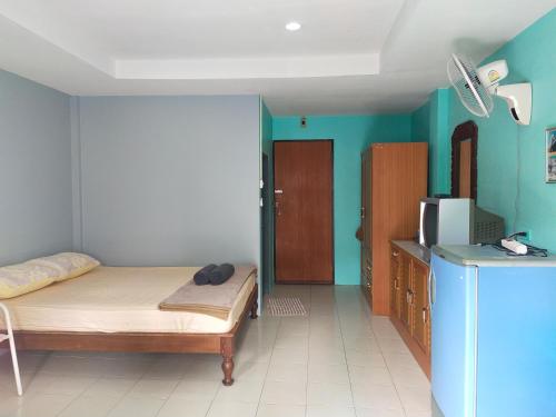 a small room with a bed and a refrigerator at Phonsomboon Guesthouse in Koh Tao