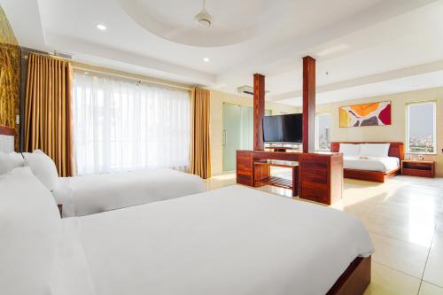 a hotel room with two beds and a television at Hotel Soco in Da Nang