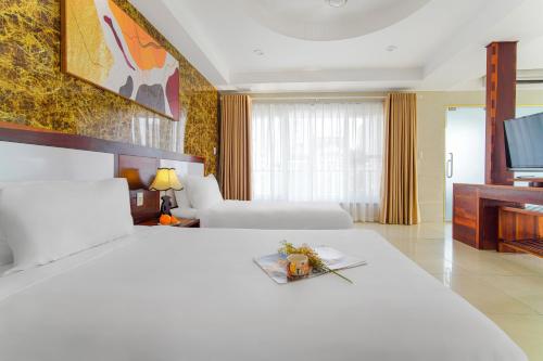 a hotel room with two beds and a flat screen tv at Hotel Soco in Da Nang